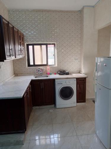 a kitchen with a washing machine and a refrigerator at شقة ام نوارة الحديثة in Amman