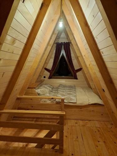 a bed in the middle of a room in a tree house at Wooden cottages "KONAK" in Šavnik