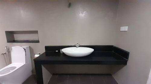 a bathroom with a sink and a toilet at Coco Villa Cinnamon in Negombo