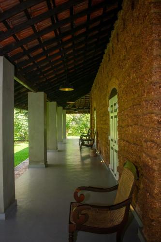 a row of benches sitting next to a brick wall at Coco Villa Cinnamon in Negombo