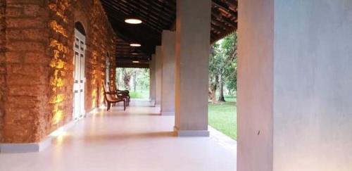 an empty hallway of a brick building with a chair at Coco Villa Cinnamon in Negombo