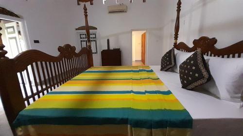 a bedroom with a bed with a colorful blanket on it at Coco Villa Cinnamon in Negombo