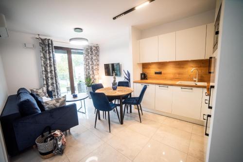a kitchen and living room with a table and a couch at Apartamenty Belni Hel Edyta i Maciej Wolak in Hel