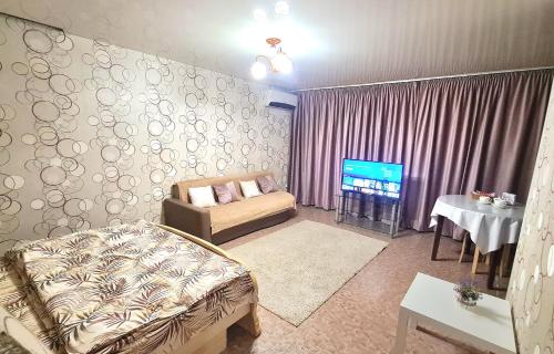 a living room with a couch and a tv at 1 комнатная квартира в центре in Uralsk