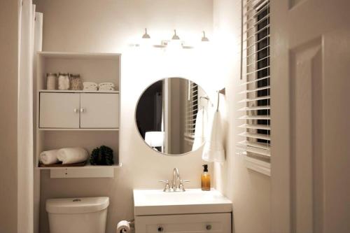 ein Bad mit einem Waschbecken und einem Spiegel in der Unterkunft Spacious Oasis in Quiet Suburb in Jonesboro