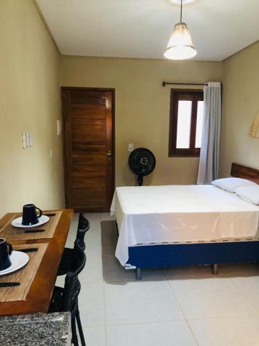 a bedroom with a bed and a table and a desk at Suite Compacta Wind Jeri in Jericoacoara