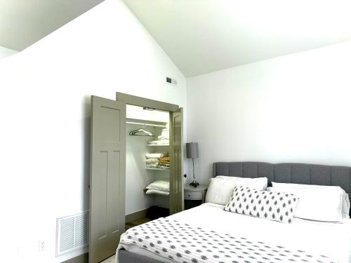 ein weißes Schlafzimmer mit einem Bett und einem Spiegel in der Unterkunft Brand new built! Pond, kayaks, hot tub,fire pit,grill… in Asheville