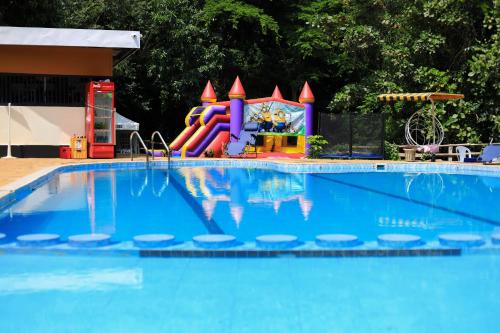 une piscine avec un toboggan et une aire de jeux dans l'établissement Hidden Treasure Lodge Chuka, à Chuka