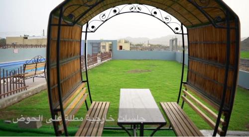 a gazebo with a bench and a green field at Bonsian in Ghumrah