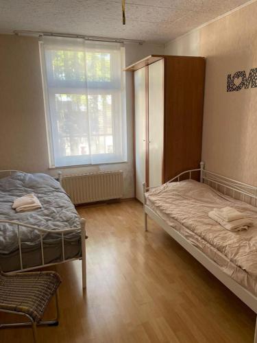 a bedroom with two beds and a large window at Apartment BOZ Solingen in Solingen