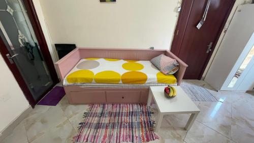 a bed with a yellow and white comforter in a room at Shared Studio Bedspace Next to AUH Airport -Males- in Abu Dhabi
