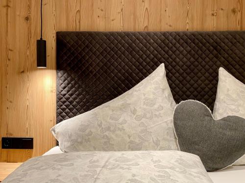 una cama con una almohada de corazón encima en Chalet & Almhostel Alpenperle - Selbstversorger Unterkunft, en Tannheim