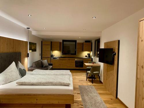 um quarto com uma cama e uma sala de estar em Chalet & Almhostel Alpenperle - Selbstversorger Unterkunft em Tannheim