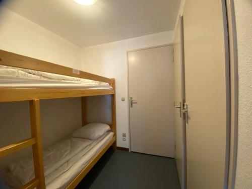 a room with two bunk beds and an open door at Studio Morillon 1100, 1 pièce, 4 personnes - FR-1-642-75 in Morillon