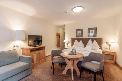 a hotel room with a bed and a table and chairs at Hotel Hubertus in Sölden