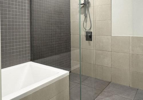 a bathroom with a shower with a tub and a sink at Dubai Frame view, 5 mins to Burj Khalifa in Dubai