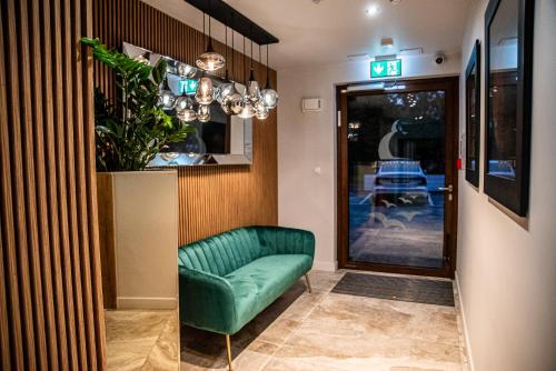 a green couch in a hallway next to a door at Apartamenty Belni Hel Edyta i Maciej Wolak in Hel