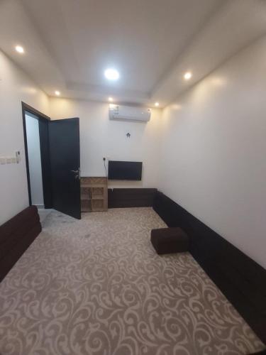 um quarto com um quarto com um sofá e uma porta em شقة واسعة و أنيقة em Quaniya