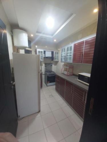 uma grande cozinha com um frigorífico branco em شقة واسعة و أنيقة em Quaniya