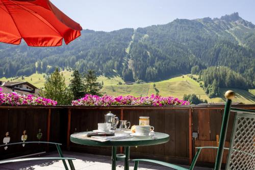 a table and chairs on a balcony with a view of a mountain at Pension Gulla - Ferienhaus Appartements B&B in Neustift im Stubaital