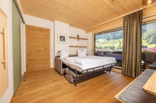 a bedroom with a bed and a large window at Pension Gulla - Ferienhaus Appartements B&B in Neustift im Stubaital