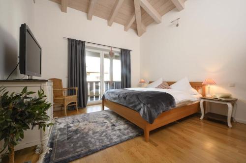 um quarto com uma cama e uma televisão num quarto em Ferienhaus Windschäufeln in Garmisch-Partenkirchen em Garmisch-Partenkirchen