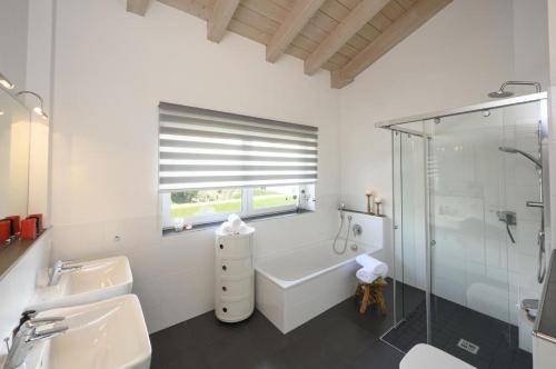 uma casa de banho com uma banheira, um chuveiro e um lavatório. em Ferienhaus Windschäufeln in Garmisch-Partenkirchen em Garmisch-Partenkirchen