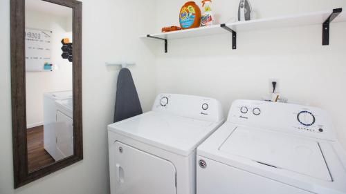 a laundry room with two washers and a mirror at 5 mins to Speedway! Walk to Zoo, WR park, IUPUI! in Indianapolis