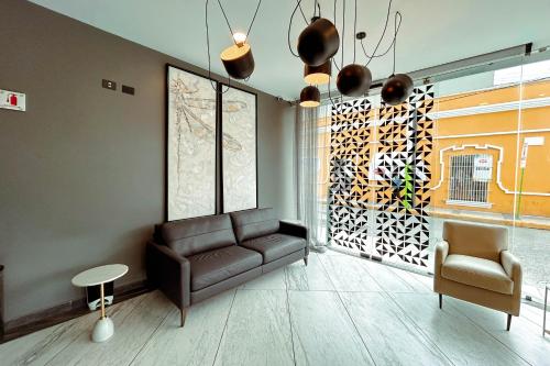 a living room with a couch and a chair at HUNICO HOTEL in Tulancingo