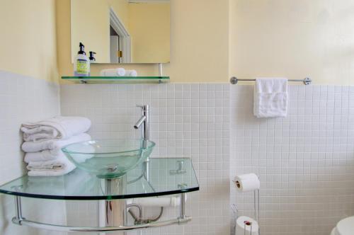 a bathroom with a glass sink and a toilet at Walkers Paradise APT with Amenities, King St 1 mi in Alexandria