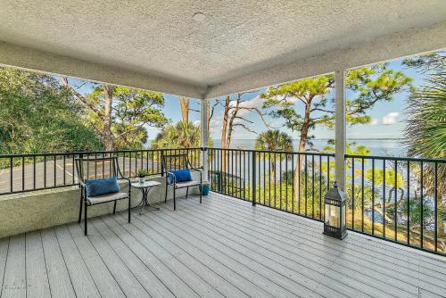 a balcony with two chairs and a view of the water at Florida Space Coast Waterfront Retreat in Cocoa
