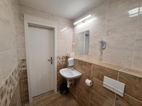 y baño con lavabo y espejo. en Alcorso Pension, en Banská Bystrica