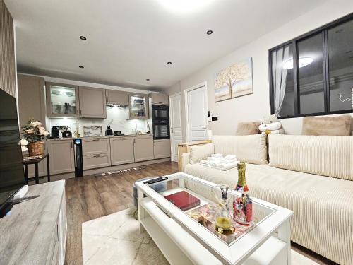 un salon avec un canapé blanc et une cuisine dans l'établissement Your cozy cove by Paris, au Kremlin-Bicêtre