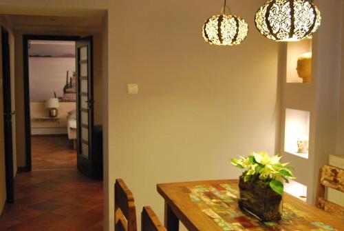 uma sala de jantar com uma mesa e lustres em Spacious apartment in green district. em Breslávia