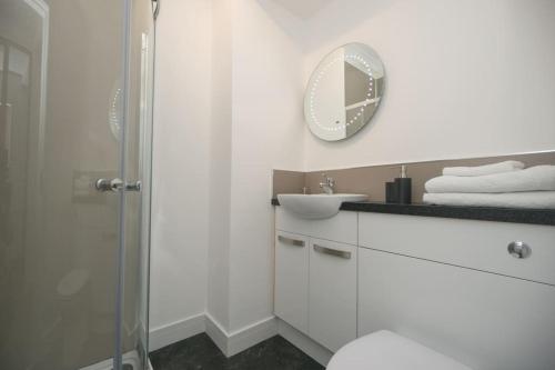 a bathroom with a toilet and a sink and a mirror at Elgin, home from home in Elgin