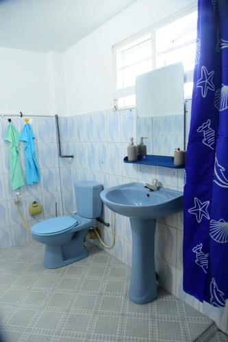 a bathroom with a blue toilet and a sink at GK Home Stay in Hikkaduwa