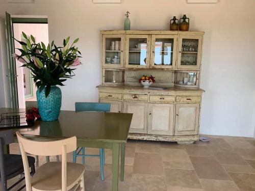a dining room with a table and a cabinet at Trullo il Gatto Nero in Ostuni