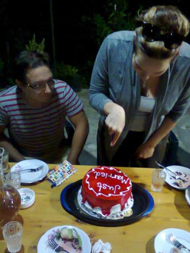 a woman cutting a red birthday cake on a table at Giorgi's Homestay in Kutaisi