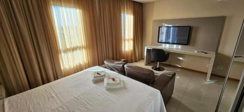 a hotel room with a table and a television at Flat particular no Hotel Jade Park Sul Brasília B812 in Brasilia