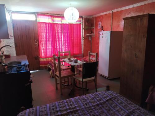 a kitchen with a dining room table and a refrigerator at Alojamiento económico en El Bolsón in El Bolsón