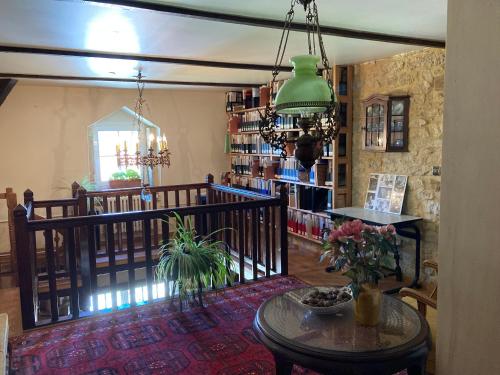 a living room with a table and a room with books at Maison Les Beaux Arts in Mouzay