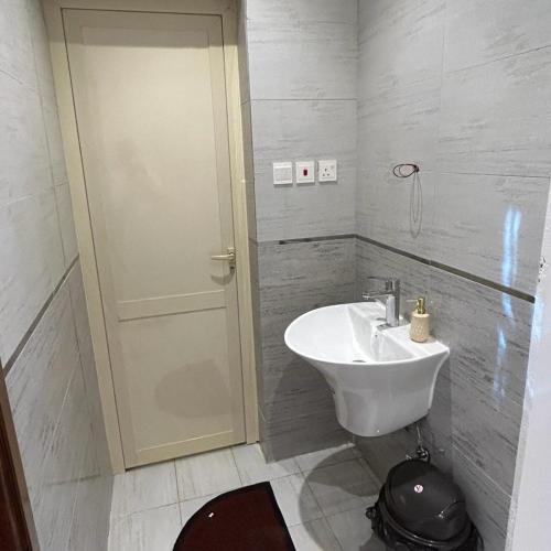 a bathroom with a white sink and a door at استراحه الفخامة in Madain Saleh