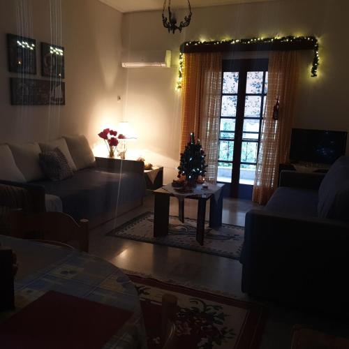 a living room with a christmas tree and a couch at Myrto's Apartment No15 in Loutra Oraias Elenis 