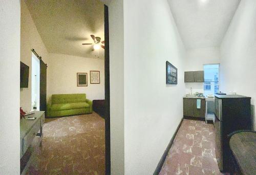 a living room with a green couch and a kitchen at Confortable Loft MN 960 D Centro Mty cerca de todo in Monterrey