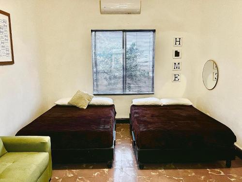 two beds in a room with a couch and a window at Confortable Loft MN 960 D Centro Mty cerca de todo in Monterrey