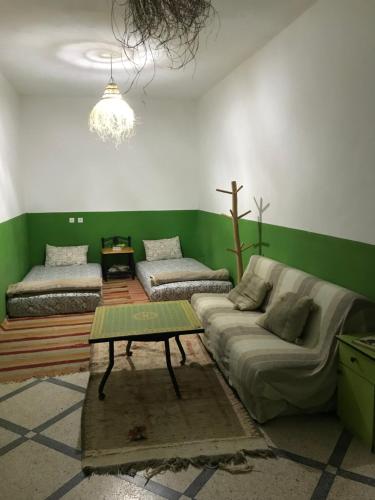 a living room with a couch and a table at Green IGR Guesthouse in Agadir