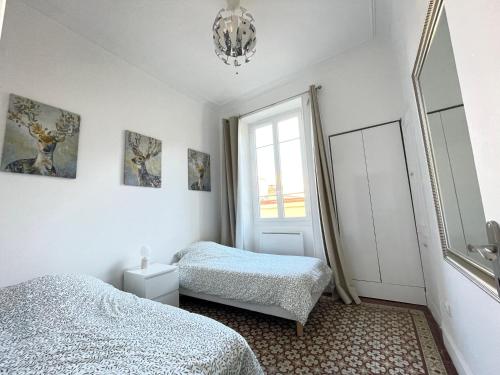 1 dormitorio con 2 camas y ventana en Appartemment Nimes Arènes, en Nimes