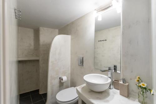 a white bathroom with a sink and a mirror at The Naxos Loft with view of the Castle in Naxos Chora