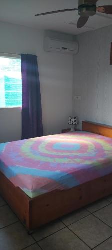 a bedroom with a large bed with a colorful comforter at Raihei Location maison d'hôtes in Bora Bora