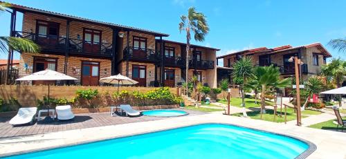 Villa con piscina frente a una casa en Pousada Catavento en Flecheiras